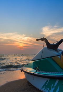 Jet ski on beach against blue sky and sunset