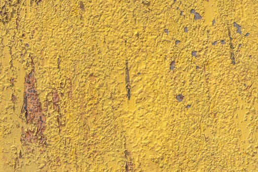 fragment of an iron surface is covered with yellow color paint, which has long been under the influence of different climatic conditions