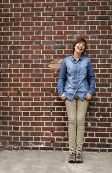 Outdoor portrait of a woman in front of a brick wall