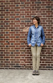 Outdoor portrait of a woman in front of a brick wall