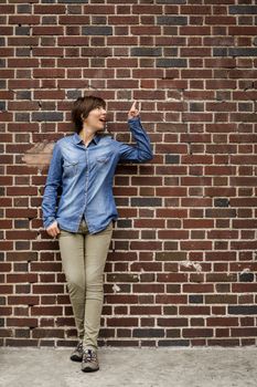 Outdoor portrait of a woman in front of a brick wall