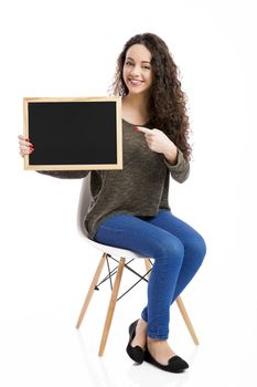 Beautiful and happy woman showing something on a chalkboard