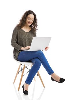 Beautiful and happy woman working with a laptop, isolated over white background 