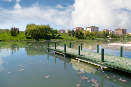 Landscape view of Porsuk River along Eskisehir with meadow area around, on bright blue sky background.