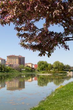 Landscape view of Porsuk River along Eskisehir with meadow area around, on bright blue sky background.
