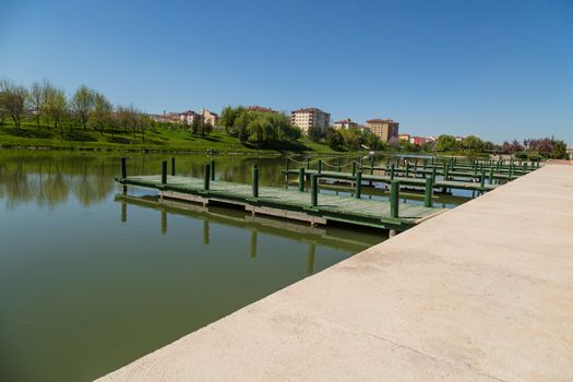 Landscape view of Porsuk River along Eskisehir with meadow area around, on bright blue sky background.