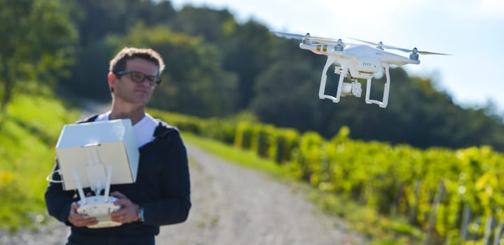 Man flying drone in wineyard, Champagne, France