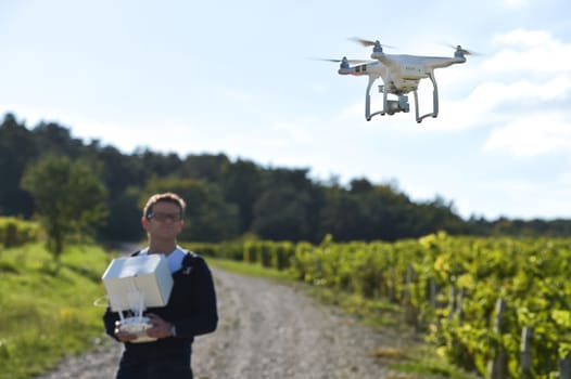 Man flying drone in wineyard, Champagne, France