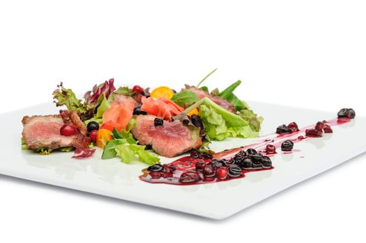 Grilled veal, pork or beef meat with cranberry and blackcurrant sauce, ginger and fresh vegetable salad