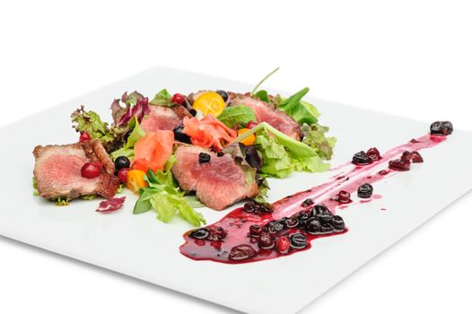 Grilled veal, pork or beef meat with cranberry and blackcurrant sauce, ginger and fresh vegetable salad