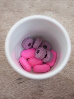 Purple and pink pills in a glass pie.