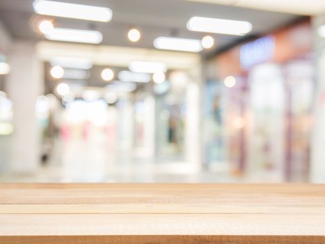 Wooden board empty table in front of blurred background. Perspective light wood over blur in shopping mall - can be used for display or montage your products. Mock up for display of product.