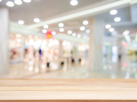 Wooden board empty table in front of blurred background. Perspective light wood over blur in shopping mall - can be used for display or montage your products. Mock up for display of product.