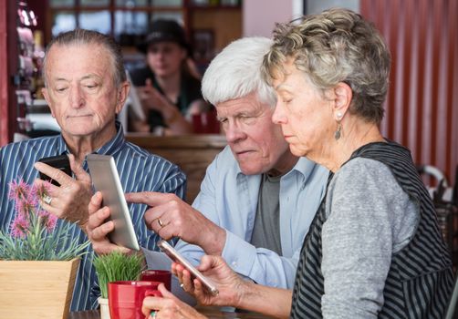 Mature friends using wifi in a coffeehouse