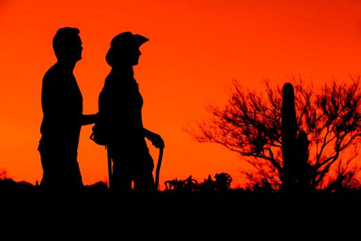 Two afternoon desert hikers in the American Southwest in silhouette