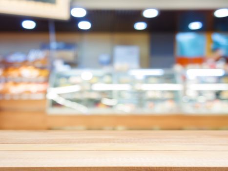 Wooden board empty table in front of blurred background. Perspective light wood over blur in bakery shop - can be used for display or montage your products. Mock up for display of product.