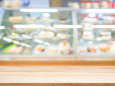 Wooden board empty table in front of blurred background. Perspective light wood over blur in bakery shop - can be used for display or montage your products. Mock up for display of product.