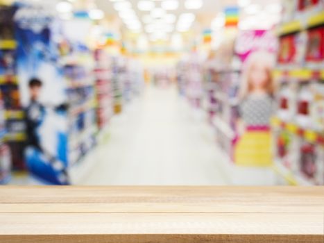 Wooden board empty table in front of blurred background. Perspective light wood over blur in kids toys store - can be used for display or montage your products. Mock up for display of product.