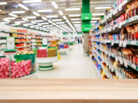 Wooden board empty table in front of blurred background. Perspective light wood over blur in supermarket - can be used for display or montage your products. Mock up for display of product.