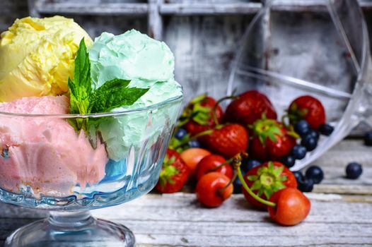 Bowl with fruit ice cream scattered on background of blueberries