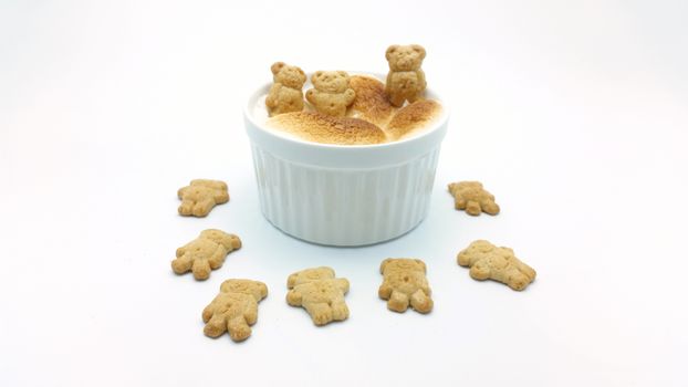 S'More dip with bear shape cookies on white background