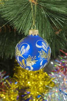 beautiful Christmas tree toy hanging on green spruce branch