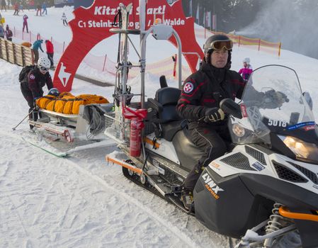 Rescuers carry the snow in the mountains on a sled injured skier