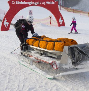Rescuers carry the snow in the mountains on a sled injured skier