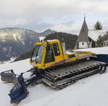 yellow snowcat dub snow on the slopes of the Alps