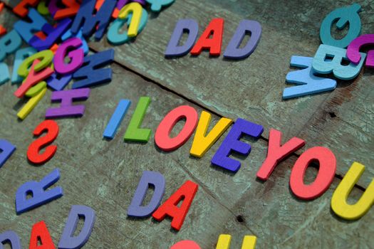 I love you dad message for father, group of colourful letters to happy father day, wooden alphabet wood background