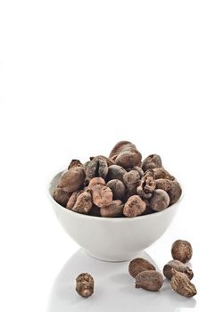 Cup full of shea nuts on white background