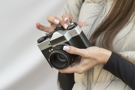 the girl with the French manicure is holding the vintage  camera
