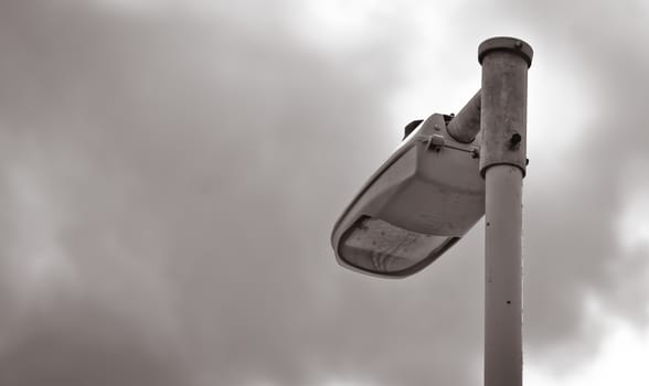Lighting equipment and pole against cloudy sky