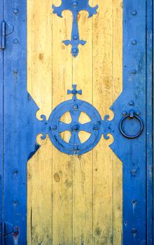 detail of old metallic hinge on spruce wooden door