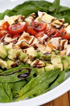 Salad with spinach, avocado, diced chicken, tomatoes and eggs