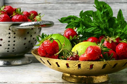 Harvest rustic strawberry and lime fruit on light background