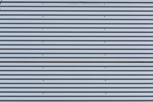 Silver-colored metal wall corrugated sheet metal background.