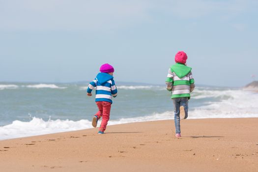 Two girls run a race on the beach seaside