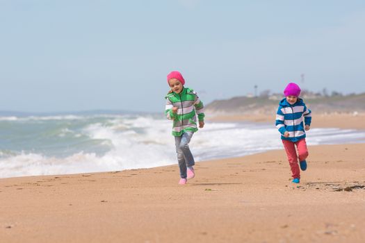 Two girls running on the beach seaside