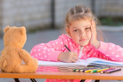 The girl does not know how to continue to draw drawing pencils