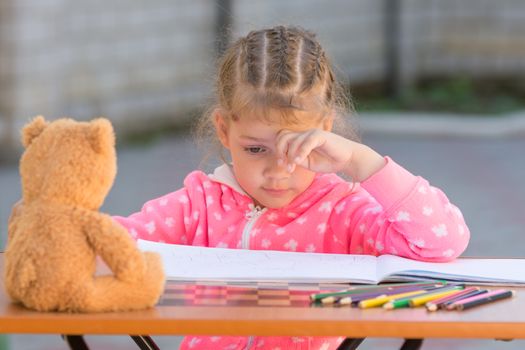 The girl does not know how to continue to draw drawing pencils