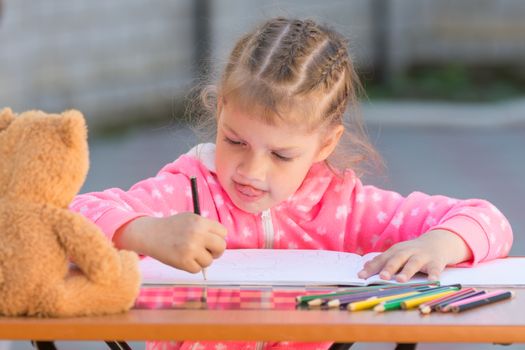 The girl stuck out her tongue enthusiastically drawing