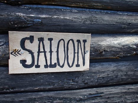 Wild west American saloon sign hanged on a wooden house   