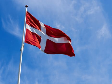 Flag of Denmark up high in the air with clear blue sky background      