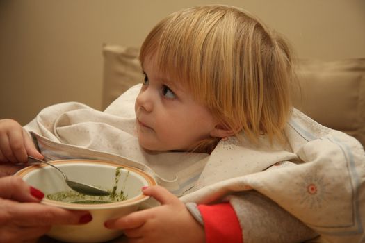Young girl enjoys eating nettle chowder