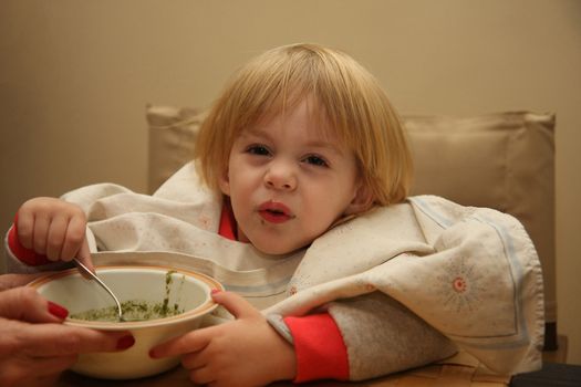 Young girl enjoys eating nettle chowder
