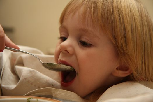 Young girl enjoys eating nettle chowder