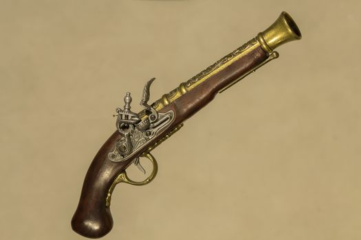 Vintage gun souvenir Brown with bronze on a beige background