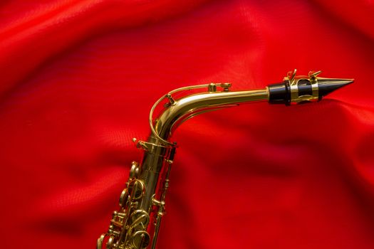 beautiful golden saxophone on delicate red silk background