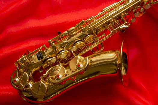beautiful golden saxophone on delicate red silk background